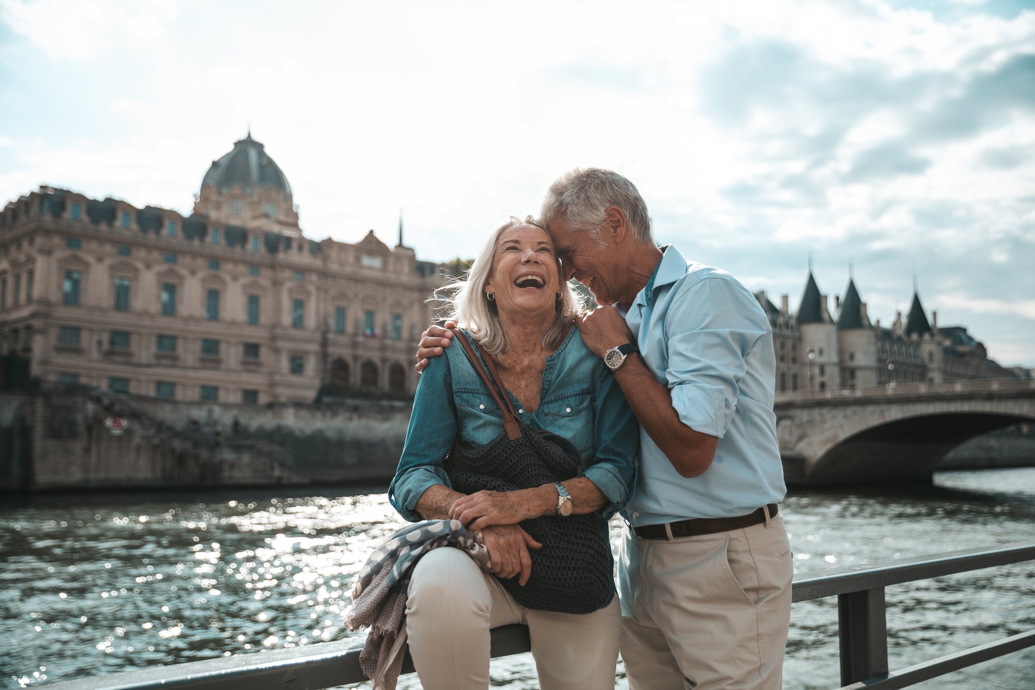 A couple poses for a picture at the Seine river in Paris