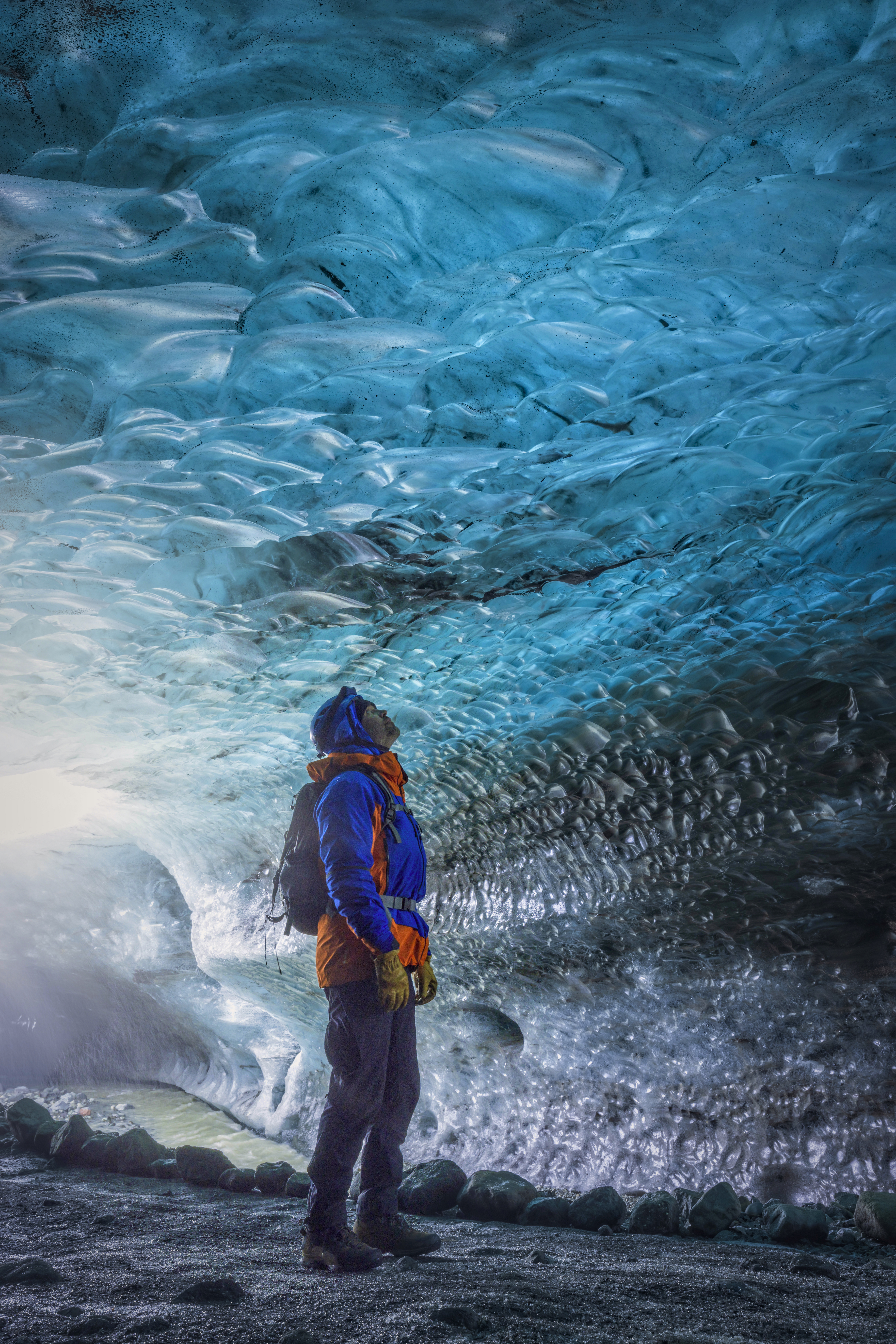 Man standing in a beautiful blue ice cave of the Vatnajökull glacier in Iceland